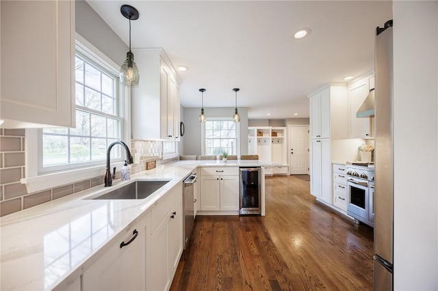 kitchen featuring wine cooler, white cabinetry, under cabinet range hood, a sink, and appliances with stainless steel finishes