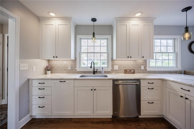 kitchen with light stone counters, a sink, white cabinetry, decorative backsplash, and stainless steel dishwasher