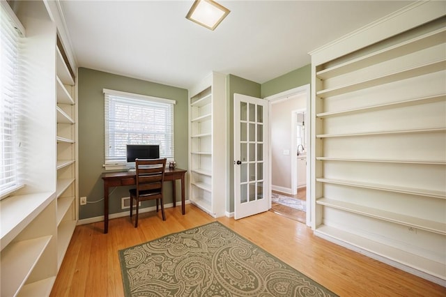 home office featuring french doors, baseboards, and light wood-type flooring