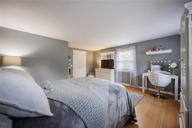 bedroom featuring baseboards and light wood finished floors