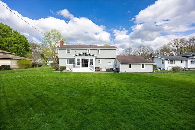 rear view of house featuring a fenced backyard, a patio, a chimney, and a yard