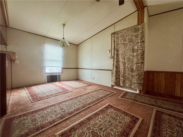 spare room with an inviting chandelier, carpet, and vaulted ceiling
