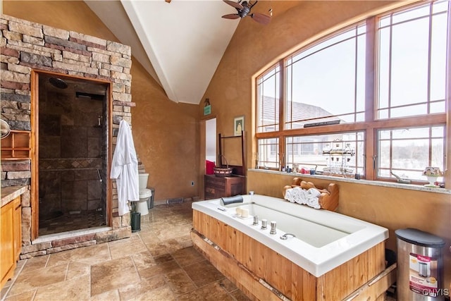 full bath with stone finish floor, a ceiling fan, a shower stall, lofted ceiling, and a bath