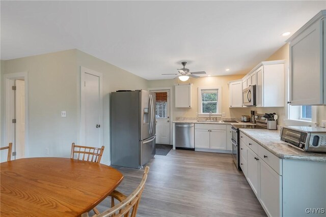216 Harry Bryant Rd, Amboy, NY 13493 - kitchen featuring stainless steel appliances, a sink, a ceiling fan, wood finished floors, and white cabinets