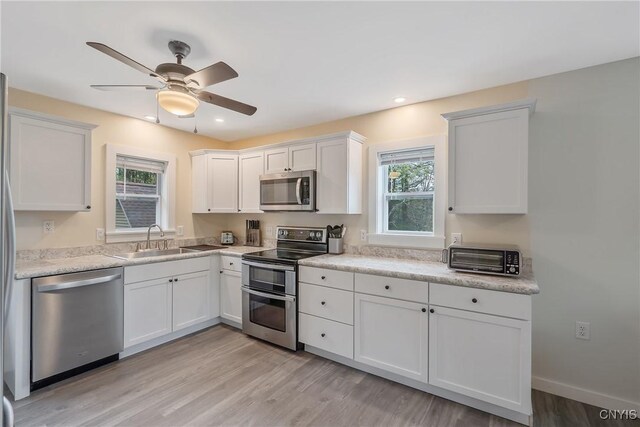 216 Harry Bryant Rd, Amboy, NY 13493 - kitchen featuring stainless steel appliances, a sink, light wood-style flooring, white cabinets, and light countertops