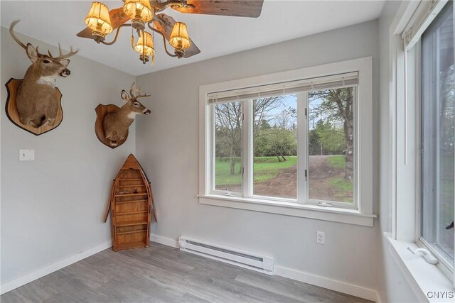 216 Harry Bryant Rd, Amboy, NY 13493 - spare room with baseboard heating, wood finished floors, baseboards, and a chandelier