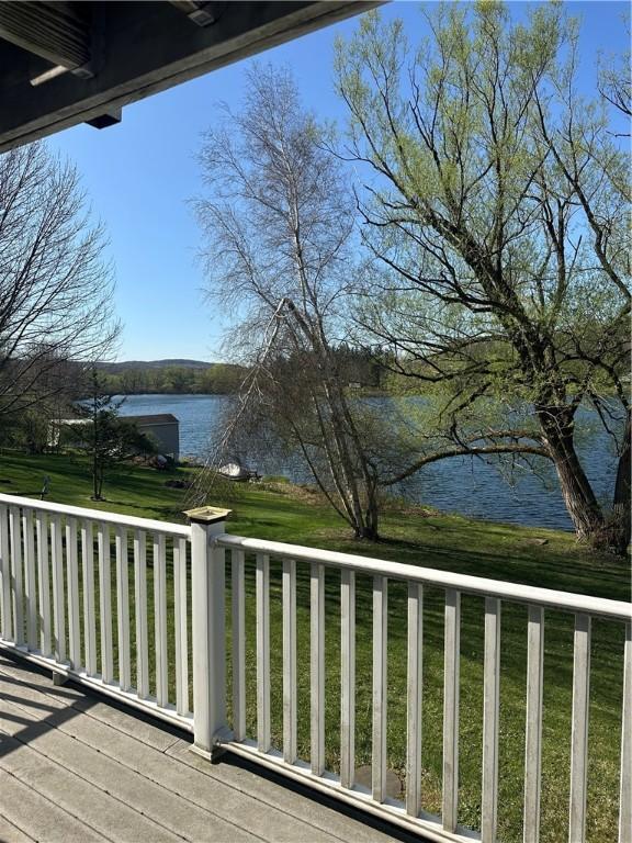 wooden terrace featuring a lawn and a water view
