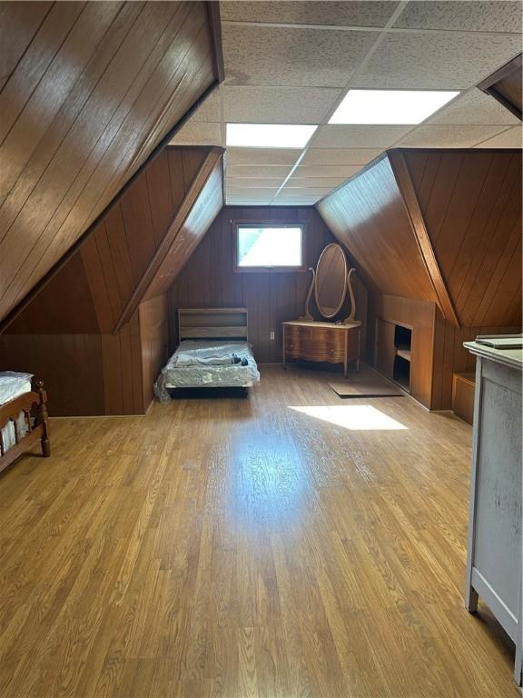 additional living space with wood finished floors and lofted ceiling