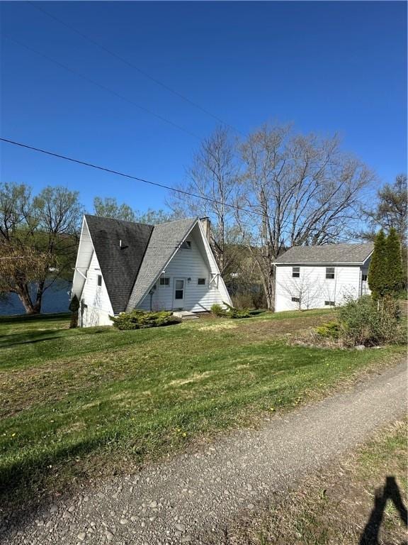 view of side of home with a lawn and a chimney