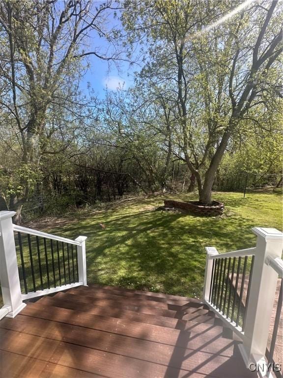 wooden terrace featuring a lawn