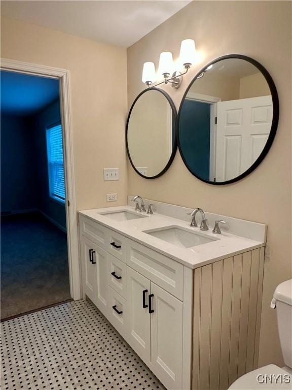 bathroom featuring a sink, toilet, and double vanity