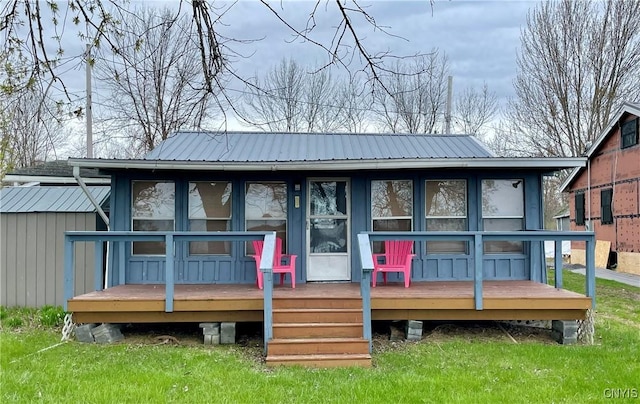 23183 Kitto Marina Dr, Brownville, NY 13634 - rear view of property with a yard, a deck, and metal roof