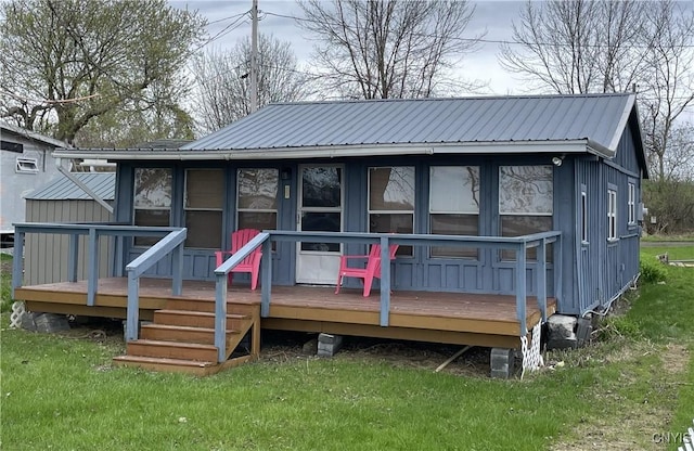 23183 Kitto Marina Dr, Brownville, NY 13634 - back of house featuring a lawn, a wooden deck, board and batten siding, and metal roof