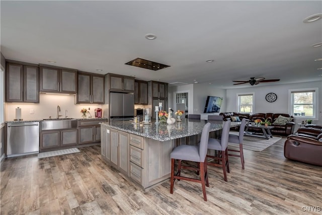 25524 County Route 57, Lyme, NY 13693 - kitchen with a sink, light wood finished floors, open floor plan, and stainless steel appliances