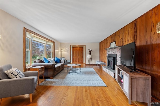 2380 E Lake Rd, Spafford, NY 13152 - living area with light wood-style flooring, a brick fireplace, and wooden walls