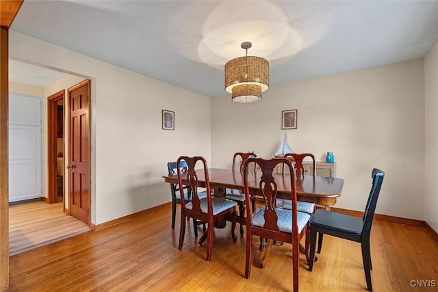 2380 E Lake Rd, Spafford, NY 13152 - dining area featuring baseboards, light wood finished floors, and a chandelier