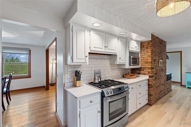 2380 E Lake Rd, Spafford, NY 13152 - kitchen featuring stainless steel appliances, baseboards, light wood-style flooring, tasteful backsplash, and white cabinetry