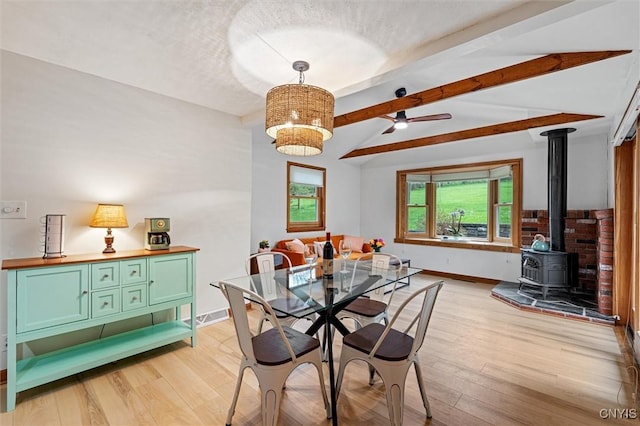 2380 E Lake Rd, Spafford, NY 13152 - dining area featuring a wood stove, light wood-type flooring, baseboards, ceiling fan, and a textured ceiling