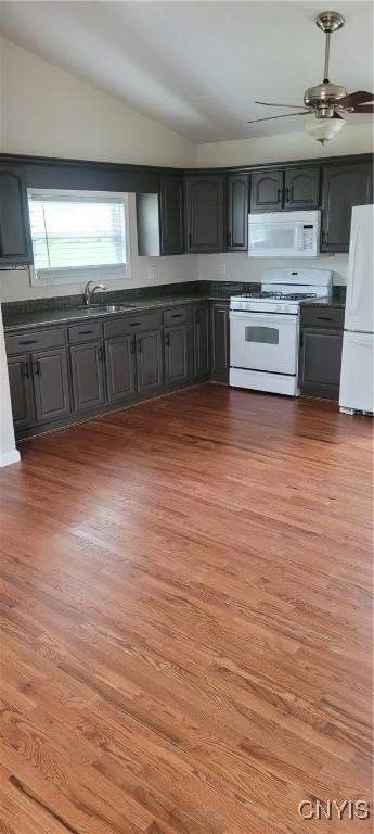206 Oak St, Fulton, NY 13069 - kitchen featuring dark countertops, wood finished floors, vaulted ceiling, and white appliances
