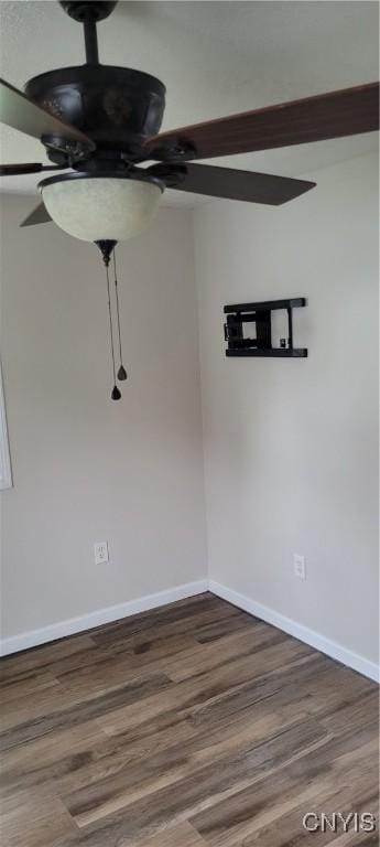 unfurnished room with a ceiling fan, baseboards, and wood finished floors