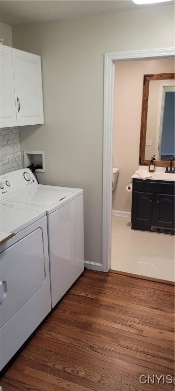 206 Oak St, Fulton, NY 13069 - laundry room with dark wood-style flooring, washing machine and dryer, cabinet space, a sink, and baseboards