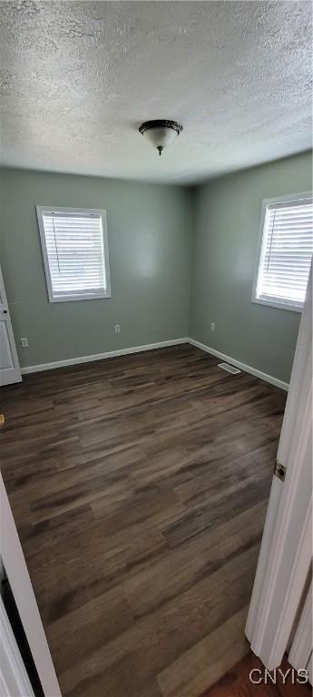 206 Oak St, Fulton, NY 13069 - unfurnished room with dark wood-style flooring, a textured ceiling, and baseboards