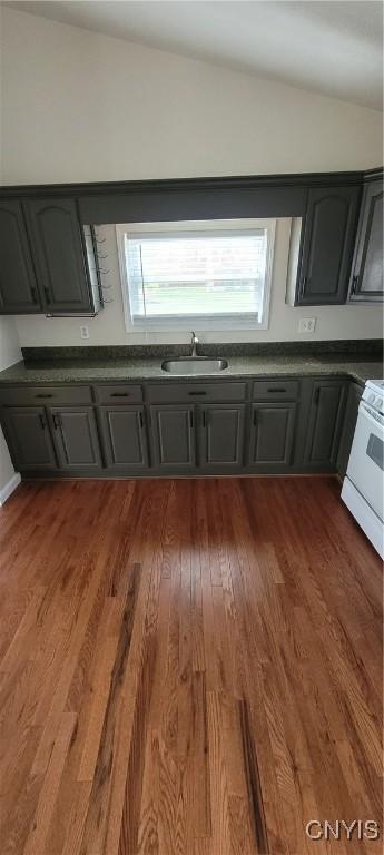 206 Oak St, Fulton, NY 13069 - kitchen with a sink, dark wood finished floors, gray cabinets, vaulted ceiling, and white range