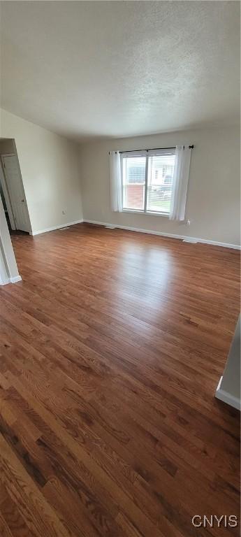 206 Oak St, Fulton, NY 13069 - unfurnished living room featuring baseboards and wood finished floors