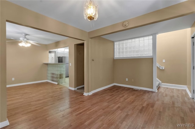 281 Roslyn Ave, Buffalo, NY 14215 - unfurnished living room featuring wood finished floors, baseboards, stairway, ceiling fan, and a chandelier