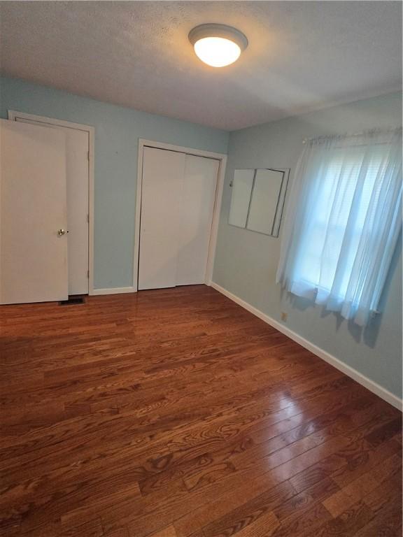 187 Cutler Ave, Corning-City, NY 14830 - unfurnished bedroom with baseboards, a closet, and wood finished floors