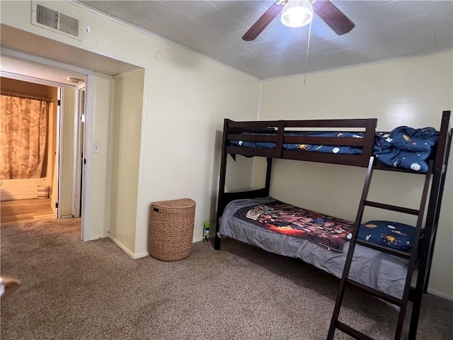 carpeted bedroom featuring visible vents, baseboards, crown molding, and ceiling fan