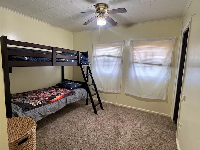 carpeted bedroom with ceiling fan and ornamental molding