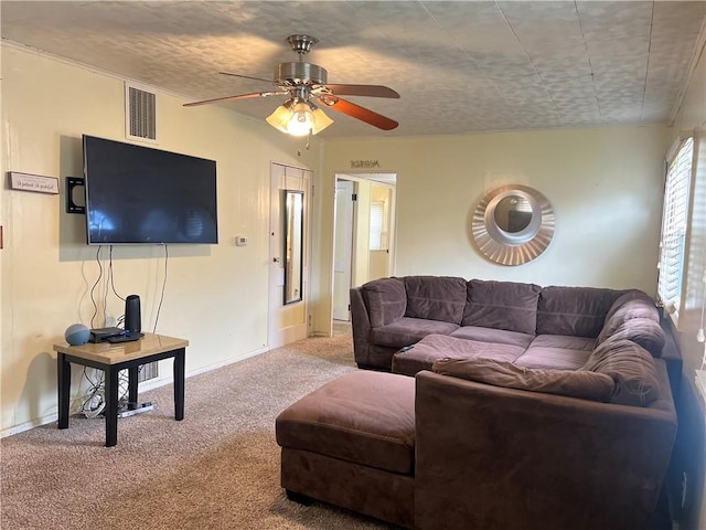 living area with carpet floors, a ceiling fan, baseboards, and visible vents