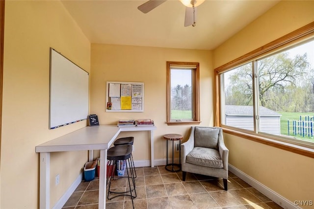 interior space with baseboards and a ceiling fan