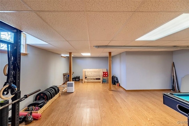 exercise area with a paneled ceiling and wood finished floors