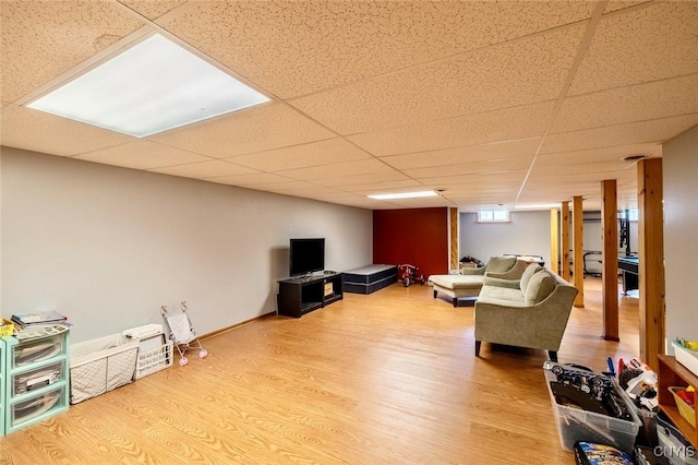 living area featuring wood finished floors and a paneled ceiling