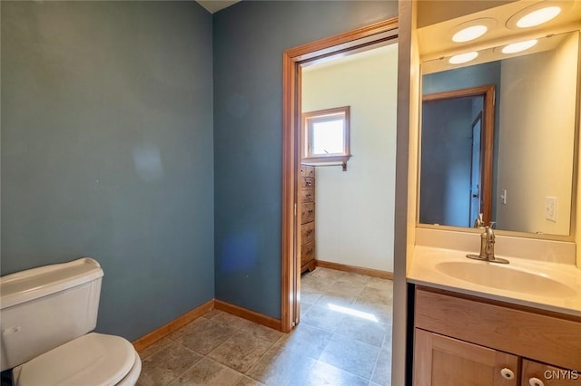 bathroom with baseboards, tile patterned flooring, vanity, and toilet