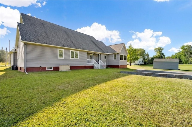 back of property with a lawn, a shingled roof, and cooling unit