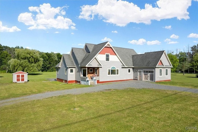 view of front facade featuring an outbuilding, a front lawn, a shed, and driveway