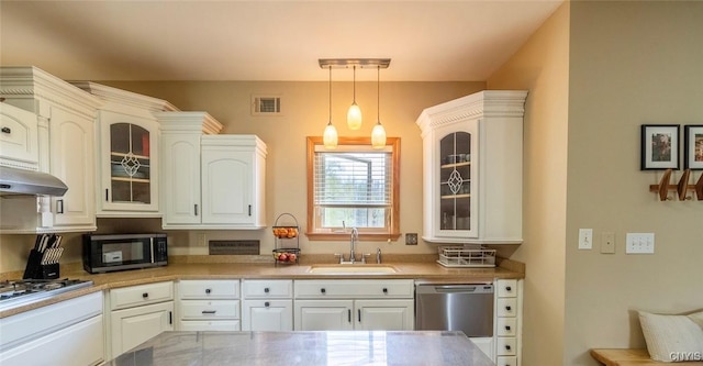 kitchen featuring appliances with stainless steel finishes, a sink, white cabinetry, visible vents, and glass insert cabinets