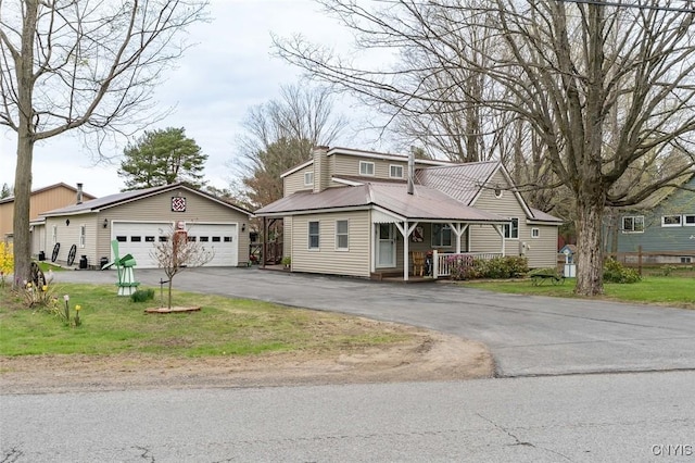 view of front of house featuring a porch, metal roof, an outdoor structure, and a garage