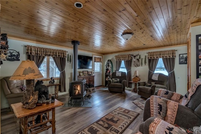 living room with wooden ceiling, a healthy amount of sunlight, and a wood stove