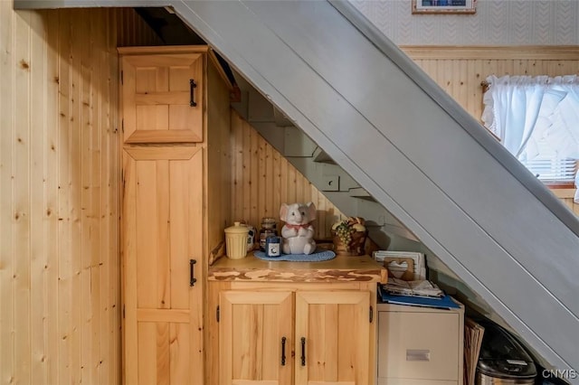 bar with wood walls, lofted ceiling, and wallpapered walls