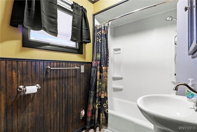 full bathroom with a sink, wainscoting, and shower / bath combo
