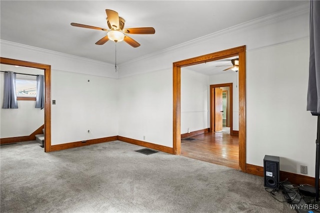 spare room featuring ceiling fan, carpet floors, baseboards, visible vents, and ornamental molding