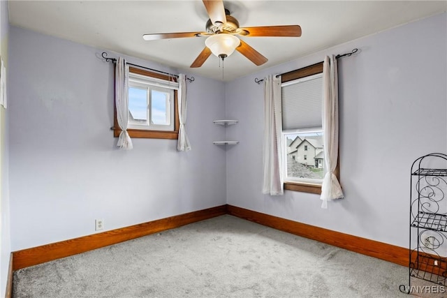 carpeted empty room with baseboards and ceiling fan