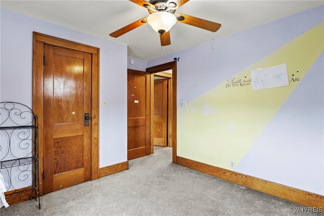 unfurnished bedroom with a ceiling fan, baseboards, and light colored carpet