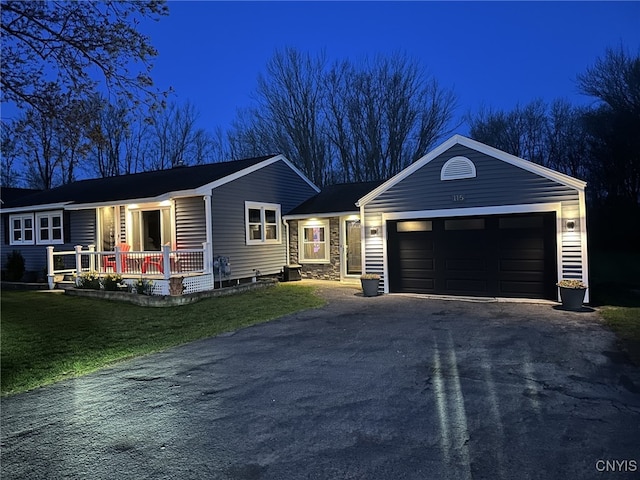 ranch-style house with an attached garage, a front lawn, and aphalt driveway