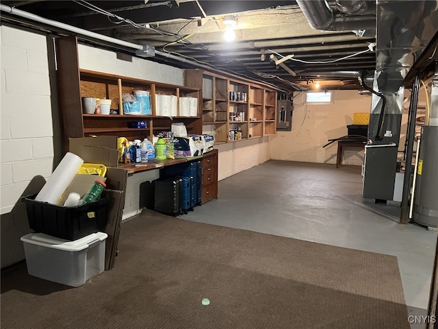 basement with water heater, heating unit, and electric panel