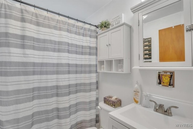 bathroom with toilet, curtained shower, and vanity